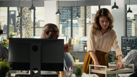 Corporate employees reviewing documentation and performance reports. Colleagues in a professional office setting collaborate on planning, projections and market research development.の写真素材