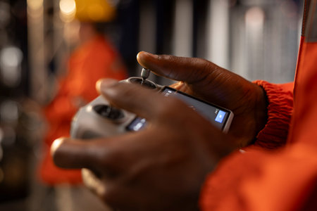 Close up of black drone pilot ensuring aerial surveillance of drilling site, using radar systems and remote control gadgets to inspect industrial equipment and oil industry infrastructure.の写真素材