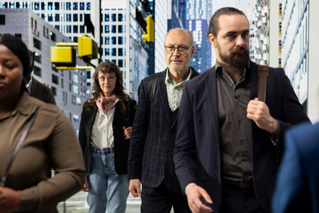 Diverse urban people moving along busy city street downtown, female and male pedestrians walking at the crosswalk during a typical commute. Modern activity and everyday city life.の写真素材