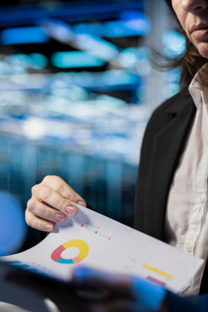 Storage rackmounts inspection, report files and specialist in server farm reading benchmarks, close up. Checkup, documentation and system administrator in data center analyzing machines parts papersの写真素材