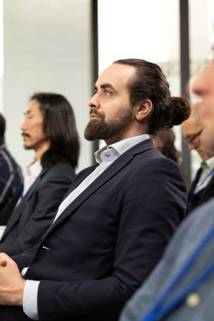 Male CEO attends professional business event in conference room with panel presentation. Listening to speaker promoting leadership and entrepreneurship values among participants.の写真素材
