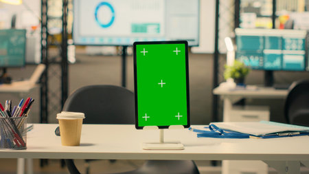 Tablet, vertical green screen, empty business office, organized work environment, modern furniture, office supplies, bright lighting, no people in workspace, interior desk setup.の写真素材