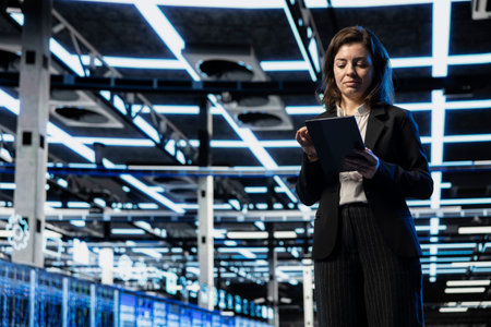 Data center software developer using tablet to do checkup on electronics processing large datasets....