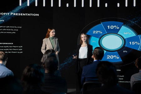 Team of young women hosting panel for business presentation with audience, professional conference summit with debate in auditorium. White collar workers attending international event.の写真素材