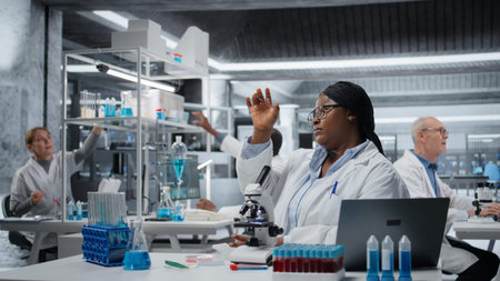 Female scientist looking at patient biopsy slide to detect abnormal cellular growth. African...