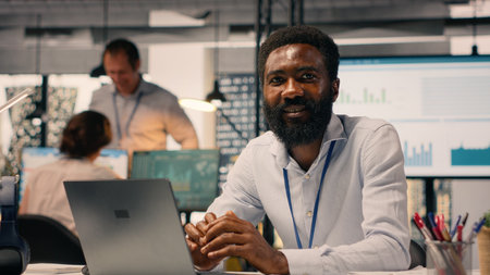 Portrait of black employee solving tasks on laptop for organizational success, doing performance...