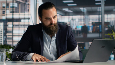 Businessman studying rental architectural plans for office relocation, looking at property...