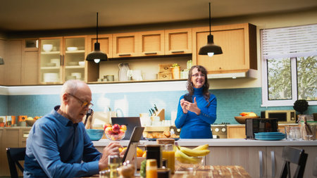 Senior woman navigating websites on smartphone and smiles in kitchen, relaxing with coffee and enjoying peaceful retired life. Retirement wellbeing, positive lifestyle and morning routine. Camera A.の写真素材