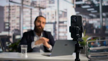 Selective focus on tripod and smartphone recording leadership coaching video, live streaming...