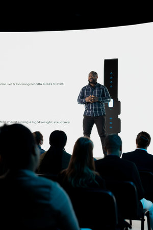 Product launch reveal with new mobile interface and design during panel presentation. African...