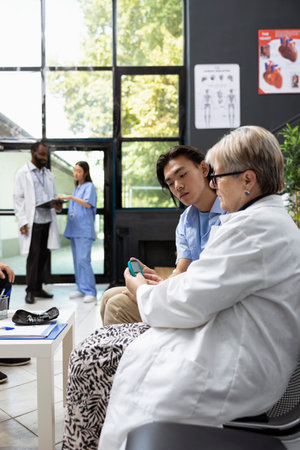 Medical professional checks patient blood glucose level with digital glucometer in clinic waiting...