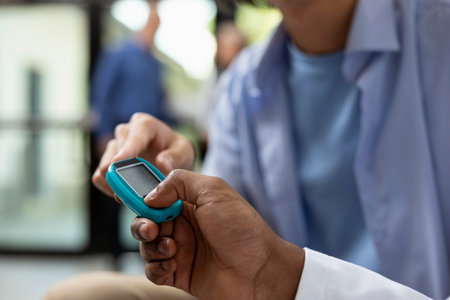 African american physician performs routine blood glucose test using test strip and digital...