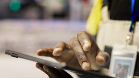 Close up of tablet used by smart factory specialist to implement automated workflows and control...