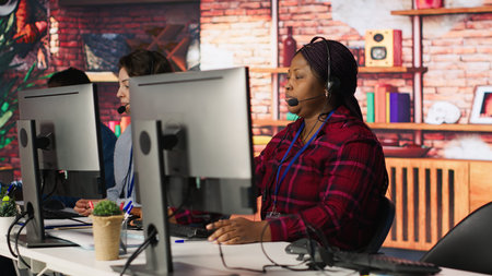 Call center worker arriving at work, using artificial intelligence on laptop to enhance customer...