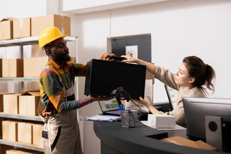 Woman passes the packages to her colleague for dispatch preparation, processing orders and managing...