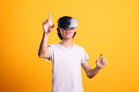 Curious young asian man wears VR headset, participating in interactive gaming simulation. Focused...