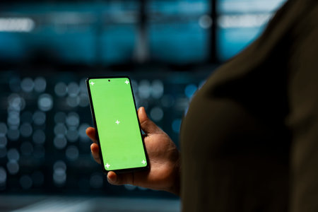 Close up of data center software developer using green screen smartphone to optimize network. Worker...