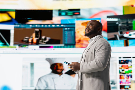 Cheerful man browsing curated video recommendations on smartphone streaming service. Happy man...