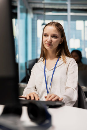 Female engineer reviewing code snippets in modern workplace, adjusting configurations. Young IT...