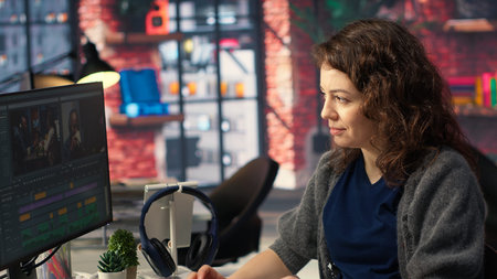Female expert editor working in video production industry at agency office, doing color grading and...