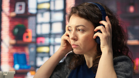 Female videographer working with dual monitors at the creative agency, editing video montage and...