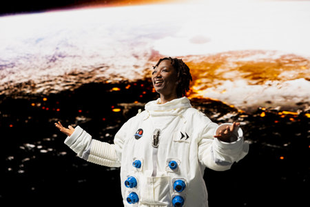 Jolly astronaut in white space suit standing in front of planet glowing horizon with arms open wide....