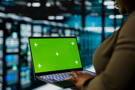 Close up of data center admin using green screen laptop to install equipment used for hosting...