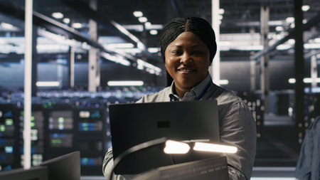 Portrait of happy technician next to data center colleagues review AI diagnostics. Cheerful IT...