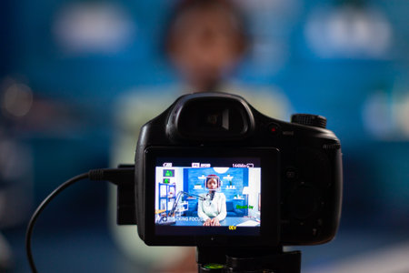 Close up professional camera sitting in front of dslr recording online show. Speaking during...