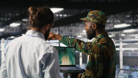 Army operators in data center using laptop to run drone control software, looking at mission map...