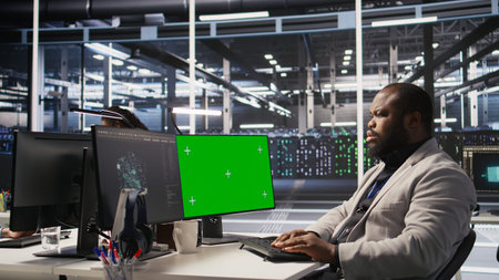 Data center admin using isolated screen PC to monitor neural network AI. Server room employee using...