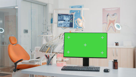 Nobody in stomatology office with green screen on computer for chroma key and mockup template....