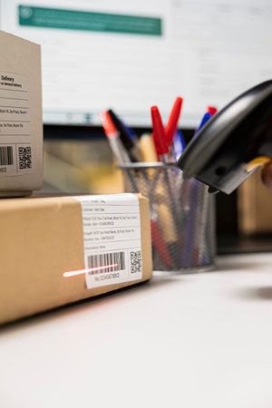Close up of employee using scanner to verify barcode and tracking info on parcel, scanning tags on...