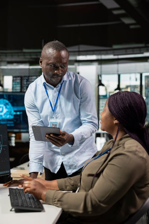 IT staff members testing AI machine learning algorithms at work. African american colleagues scaling...