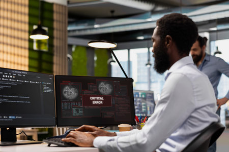 Engineer resolving critical error alert on screen in tech startup office, troubleshooting system...