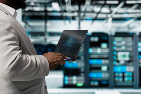 Close up of data center engineer using artificial intelligence computerized model on laptop to...