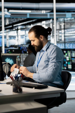 Server hub specialist looking at business data charts paperwork to pinpoint equipment performance...
