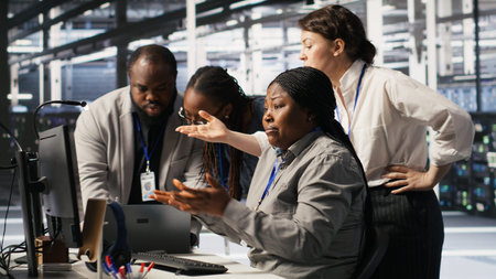Engineering team in data center panicking after receiving critical error popup on PC monitor. Server...