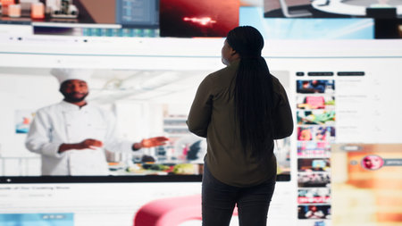 Woman entertained by video content on digital wall of screens, concept of modern digital lifestyle....