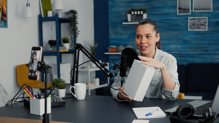 Popular tech enthusiast doing unboxing review video in living room studio. Famous social media...