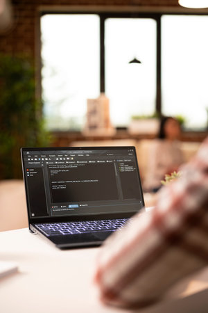 Closeup of african american freelancer writing programming scripts on digital device at home. IT...