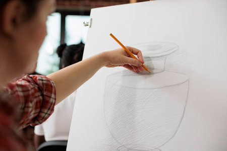 Creative process. Female artist sketching and shading vase with pencil, learning to draw and sketch...