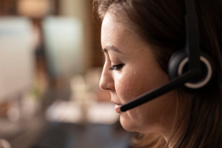 Extreme closeup of caucasian woman in a headset, demonstrating professionalism while offering online...