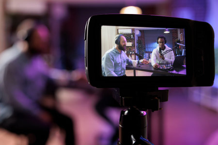 Close up shot of professional camera used to record podcast show with vlogger and guest discussing...