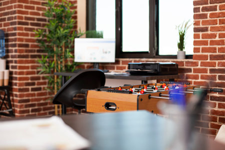 Selective focus on foosball table placed in modern brick wall workspace, ready for employees to...