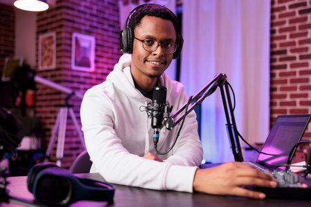Celebrity vlogger recording internet show with professional camera and sound equipment in living...