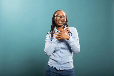 Cheerful black female model celebrates with confident dance, expressing excitement and good vibes in...
