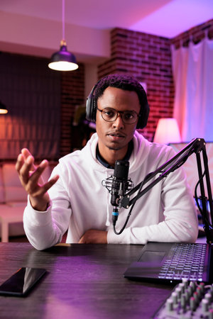 Portrait of content creator broadcasting live on streaming platform from vibrant rgb lights studio...