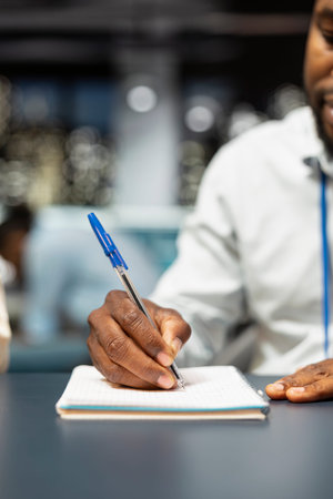 Writing down information, paperwork close up and accountant in office working overtime to finish...