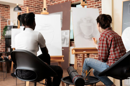 Spending time with friends at drawing workshop, two women friends sitting at easels learning to draw...